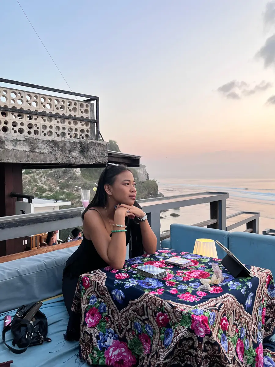 Putri Aina at her tarot table at sunset